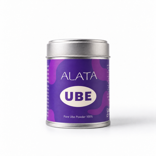A cylindrical metal tin of ALATA UBE Pure Ube Powder 100% on a clean white background. The tin has a silver lid and base, with a purple label featuring wavy patterns and a white oval containing the text 'UBE'.