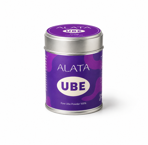 A cylindrical metal tin of ALATA UBE Pure Ube Powder on a clean white background. The tin features a purple label with a subtle wavy pattern, white text, and a silver lid.